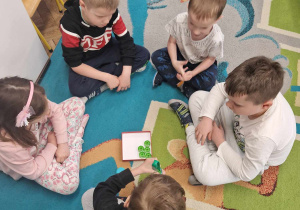 5 dzieci siedzi w kole i wykonują konkursowe zadanie