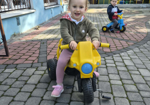 dzieci jeżdźą rowerkami po tarasie