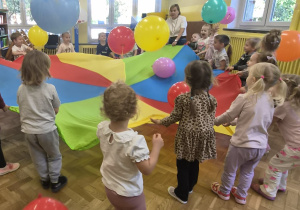 dzieci podrzucają balony na chuście