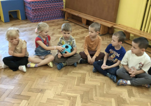 dzieci siedzą w kole
