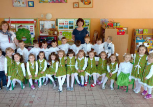 Dzieci przebrane w stroje siedzą na krzesłach w klasie z Panią Jolą i Panią IWoną