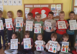 W pierwszym rzędzie siedzą: 5 dziewczynek, jeden chłopiec, na górze od lewej:9 ciu chłopców, dzieci trzymają w ręku laurki dla babci i dziadka