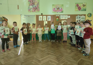 Dzieci stoją z kolorowankami misiów