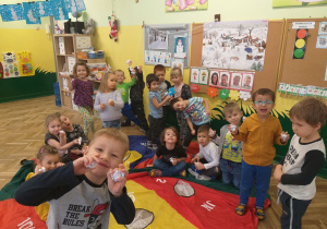 Dzieci przy chuście animacyjnej ze śnieżkami w rękach