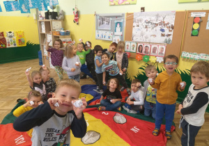 Dzieci przy chuście animacyjnej ze śnieżkami w rękach