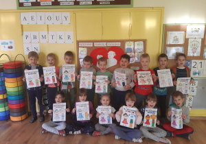 Dzieci z gr 4 pozują do zdjęcią trzymając w rękach laurki dla dziadków