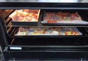piekarnik w którym są umieszczone blachy z pizzą