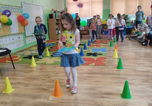 Dzieci przenoszą plastikową butelkę z wodą na plastikowym krążku