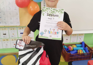 Chłopiec prezentuje zdobyty dyplom i nagrodę