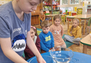Dzieci uczestniczą w zabawie badawczej z wodą