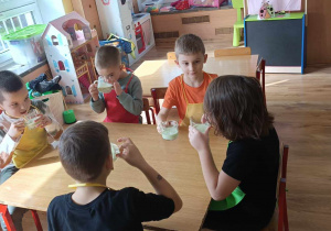 Dzieci piją przygotowany przez siebie koktajl.