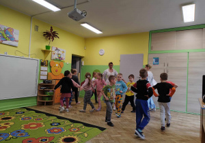 Dzieci tańczą poloneza z dwiema tancerkami.