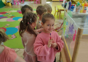 Dzieci malują farbami na folii stretch.