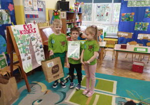 3 dzieci z drużyny zielonej prezentują swój dyplom i prezent