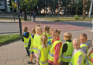 Dzieci ustawione w parach czekaja przed przejściem dla pieszych