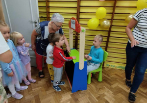 Dzieci stoją w kolejce i odbierają w kasie bilet do kina.