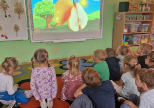 dzieci oglądają film edukacyjny o owocach