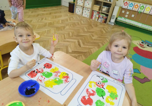 Chłopiec i dziewczynka malują farbami.