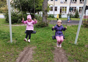 Dziewczynki bujają się na huśtawce.