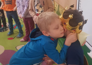 Chłopiec składa życzenia jubilatowi i go przytula