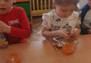 Dzieci delektują się słodyczami,które otrzymały od jubilata.