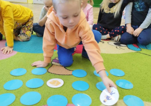 Dzieci grają w grę edukacyjną „Memory Poczta”.