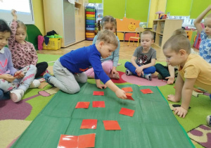 Dzieci grają w grę edukacyjną „Patriotyczne Memory”.