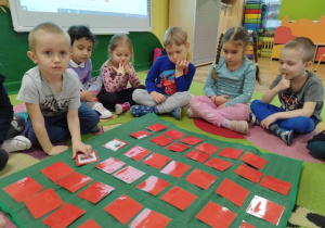 Dzieci grają w grę edukacyjną „Patriotyczne Memory”.