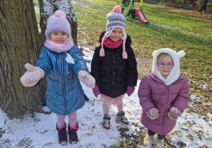 trzy dziewczynki cieszą się z pierwszego śniegu