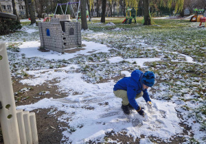 Chłopiec lepi kule ze śniegu