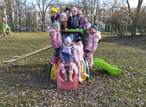 Dzieci stoją na zabawce ogrodowej i pozują do zdjęcia.