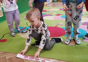 Chłopiec uklada pączkowe domino.