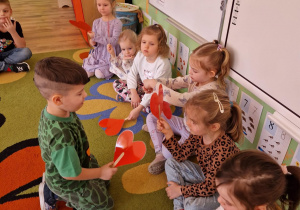 Chłopiec podaje serduszko koleżance za pomocą klamerki