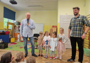 4 dziewczynki stoją pomiędzy dwoma mężczyznami