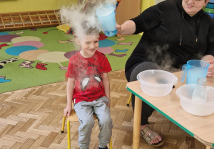 Chłopiec uczestniczy w doświadczeniu z suchym lodem