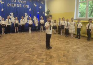 Chłopiec recytuje wiersz przez mikrofon