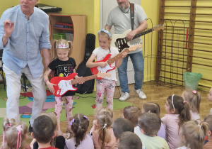 Pan i dwie dziewczynki grają na gitarach
