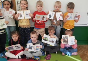 Dzieci prezentują obrazki sprzętów domowych dawniej i dziś