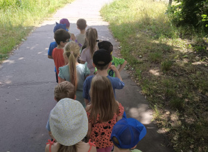 Dzieci idą przez park do biblioteki.
