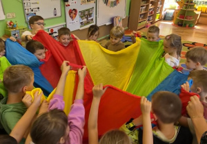 Dzieci zawijają jubilatke w chuste