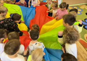 Dzieci zawijają jubilatke w chuste