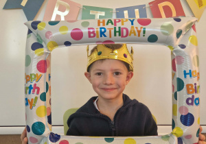 Jubilat pozuje do zdjęcia w ramce urodzinowej