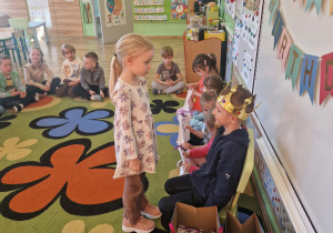 Dziewczynka składa życzenia jubilatowi i otrzymuje upominek