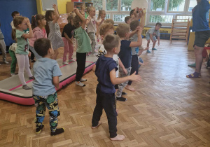 Dzieci wykonują rozgrzewkę z trenerem
