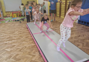 Dziewczynki skaczą jak żabki po materacu