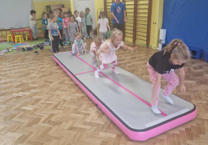 Dziewczynki skaczą jak żabki po materacu
