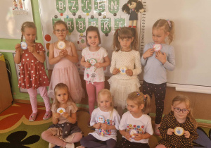 Dziewczynki prezentują medale z okazji dnia kropki