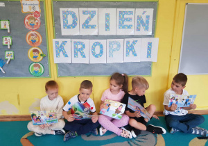 Dzieci trzymają ilustracje wykorzystane do opowiadania,,Wszystko zaczyna się od kropki"
