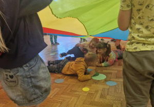 Dzieci chowają się pod kolorową chustę