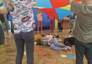 Dzieci chowają się pod kolorową chustę
